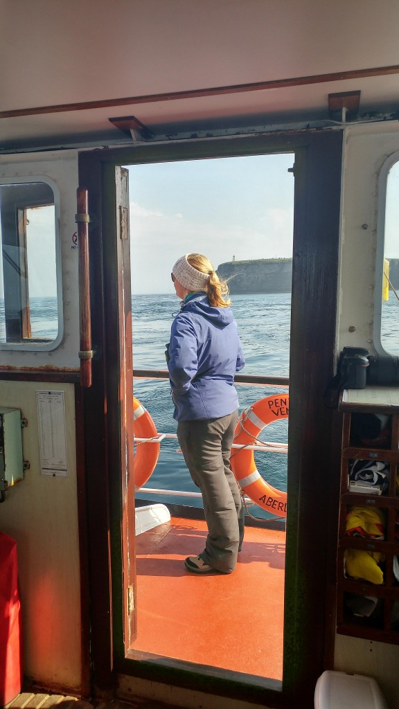 Tara Callahan - one of last year's sea watch foundation interns is attending orca watch this year and helping with ferry data collection. Duncansby head visible behind her. Photo credit: Chloe Robinson/ Sea Watch Foudation. 